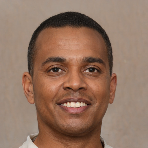 Joyful latino young-adult male with short  brown hair and brown eyes