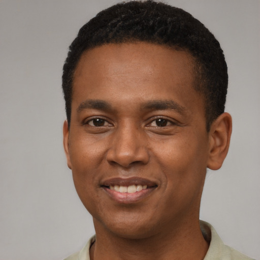 Joyful black young-adult male with short  brown hair and brown eyes