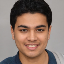 Joyful white young-adult male with short  black hair and brown eyes