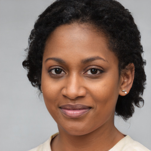 Joyful black young-adult female with medium  brown hair and brown eyes