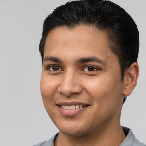 Joyful latino young-adult male with short  brown hair and brown eyes