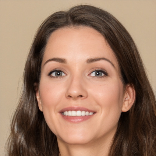 Joyful white young-adult female with long  brown hair and brown eyes