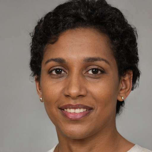 Joyful black adult female with short  brown hair and brown eyes