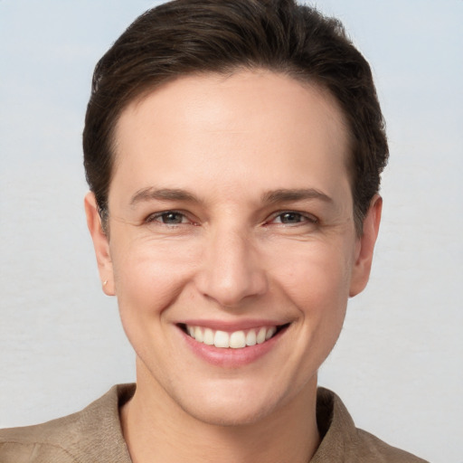 Joyful white young-adult female with short  brown hair and grey eyes