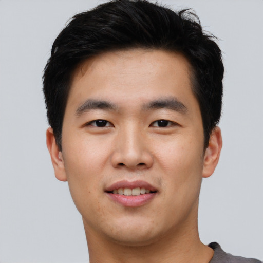 Joyful asian young-adult male with short  black hair and brown eyes