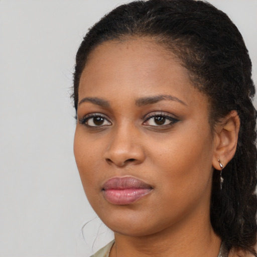 Joyful black young-adult female with long  brown hair and brown eyes