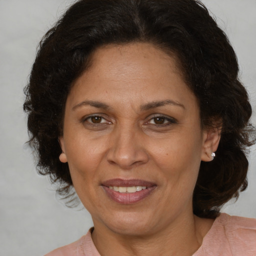 Joyful latino adult female with medium  brown hair and brown eyes