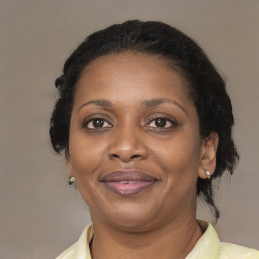 Joyful black adult female with medium  brown hair and brown eyes