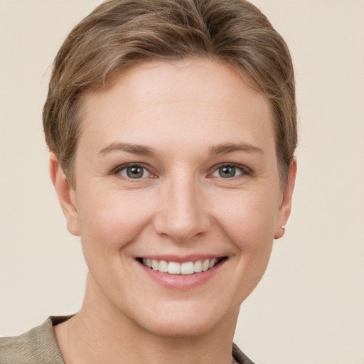 Joyful white young-adult female with short  brown hair and grey eyes