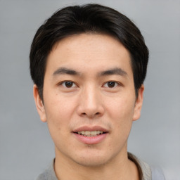 Joyful asian young-adult male with short  brown hair and brown eyes