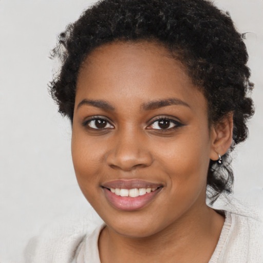 Joyful black young-adult female with short  black hair and brown eyes