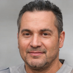 Joyful white adult male with short  black hair and brown eyes
