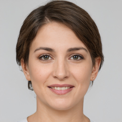 Joyful white young-adult female with medium  brown hair and grey eyes