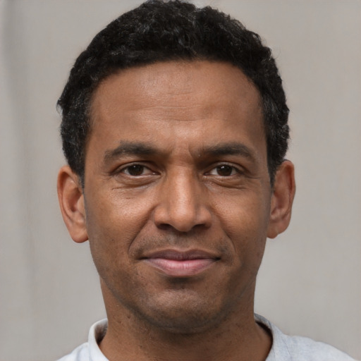 Joyful latino adult male with short  black hair and brown eyes