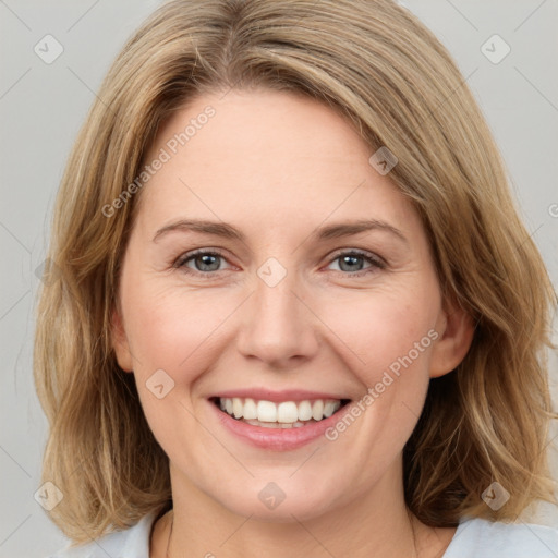 Joyful white young-adult female with medium  brown hair and green eyes