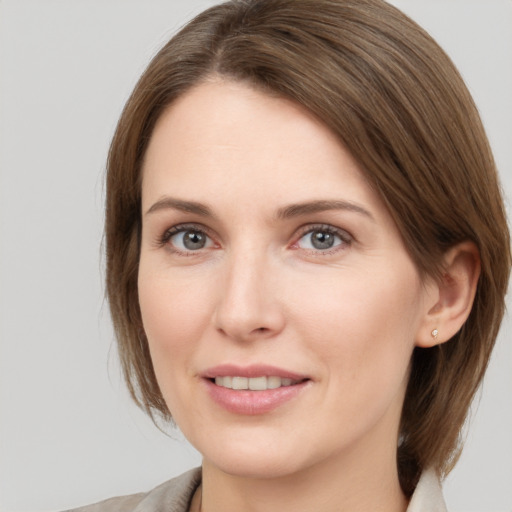 Joyful white young-adult female with medium  brown hair and grey eyes