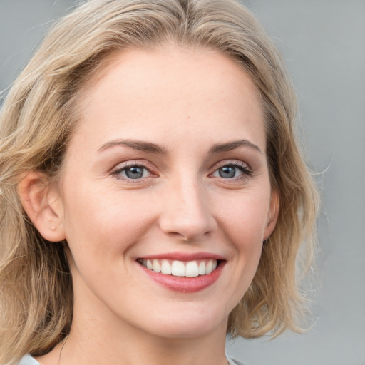 Joyful white young-adult female with medium  brown hair and blue eyes