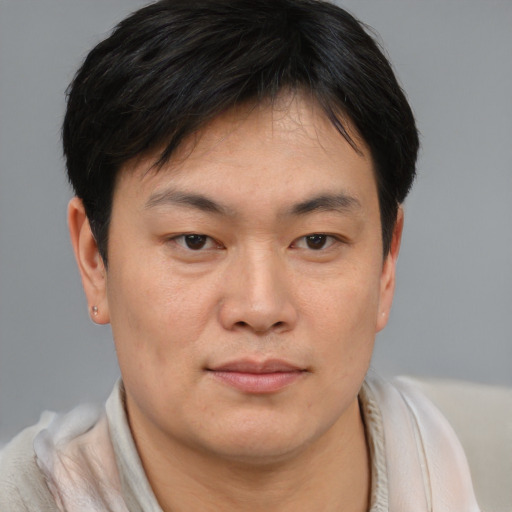 Joyful asian young-adult male with short  brown hair and brown eyes