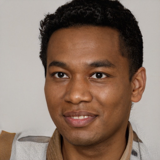 Joyful black young-adult male with short  brown hair and brown eyes