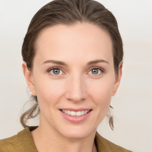 Joyful white young-adult female with medium  brown hair and grey eyes