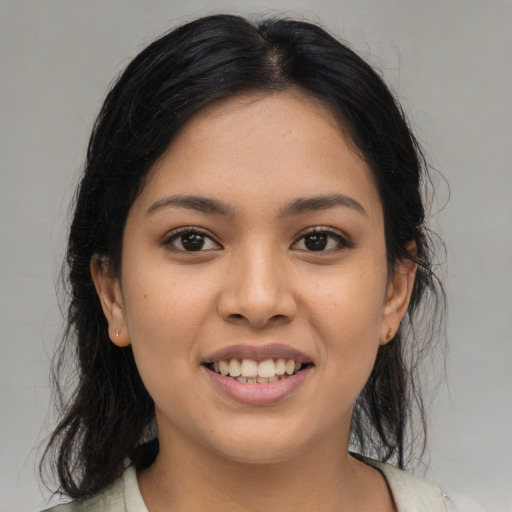 Joyful latino young-adult female with medium  brown hair and brown eyes