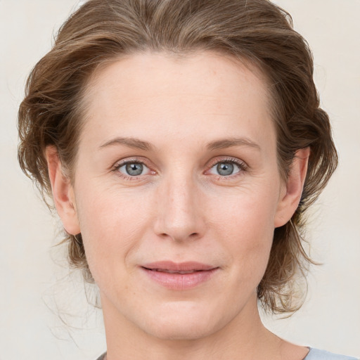 Joyful white young-adult female with medium  brown hair and blue eyes