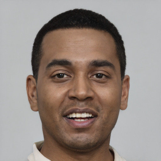 Joyful black young-adult male with short  black hair and brown eyes
