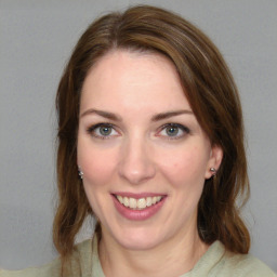 Joyful white young-adult female with long  brown hair and green eyes