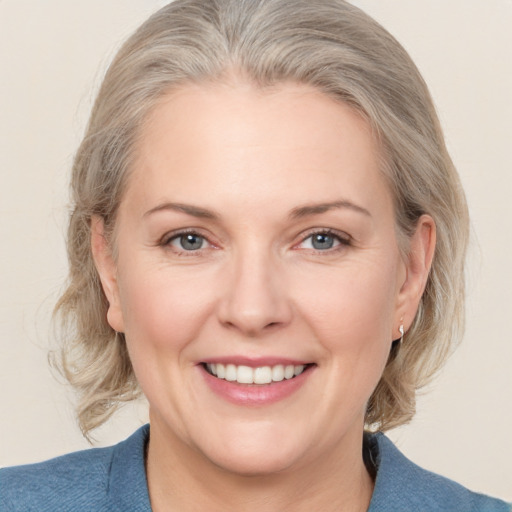 Joyful white adult female with medium  brown hair and blue eyes