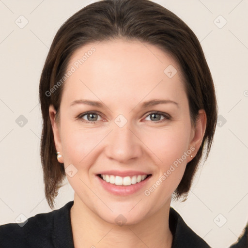 Joyful white young-adult female with medium  brown hair and grey eyes