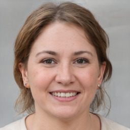 Joyful white young-adult female with medium  brown hair and grey eyes