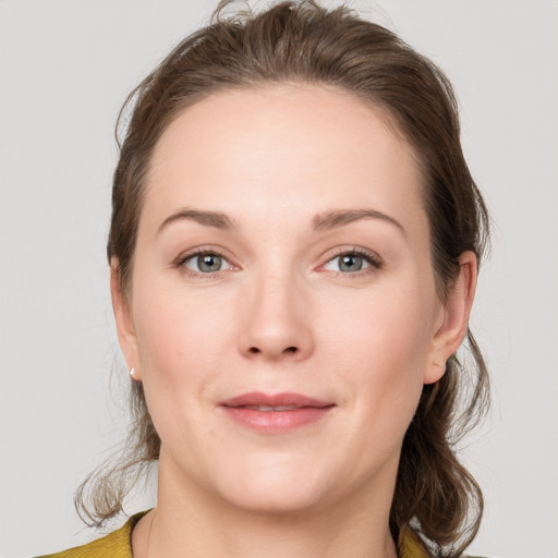 Joyful white young-adult female with medium  brown hair and grey eyes