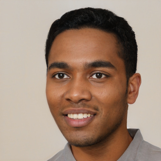 Joyful black young-adult male with short  black hair and brown eyes