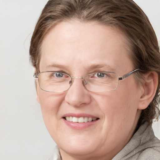 Joyful white adult female with medium  brown hair and blue eyes