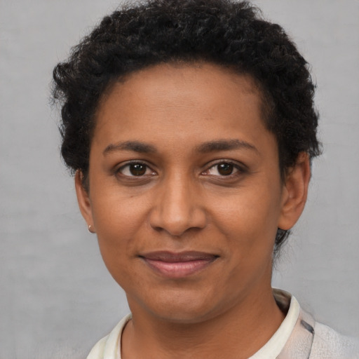 Joyful black young-adult female with short  brown hair and brown eyes