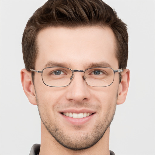 Joyful white young-adult male with short  brown hair and grey eyes