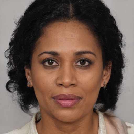 Joyful black adult female with medium  brown hair and brown eyes