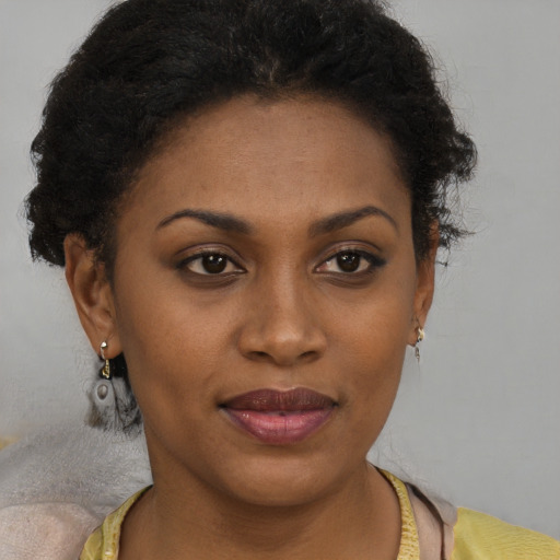 Joyful black young-adult female with short  brown hair and brown eyes