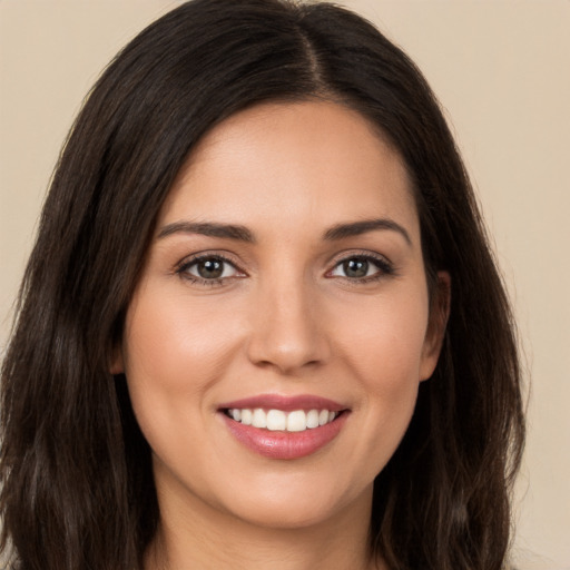 Joyful white young-adult female with long  brown hair and brown eyes