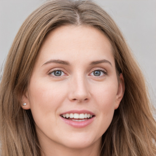 Joyful white young-adult female with long  brown hair and grey eyes