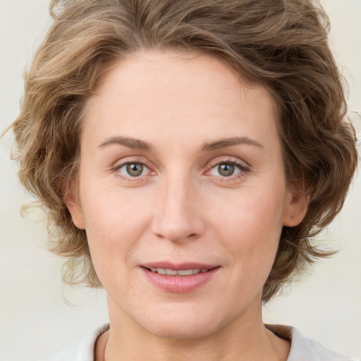 Joyful white young-adult female with medium  brown hair and green eyes