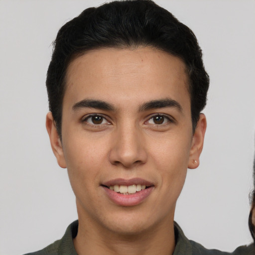 Joyful latino young-adult male with short  brown hair and brown eyes