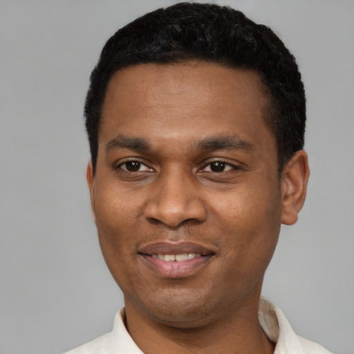 Joyful latino young-adult male with short  black hair and brown eyes