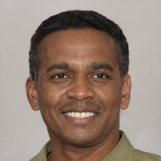 Joyful black adult male with short  black hair and brown eyes