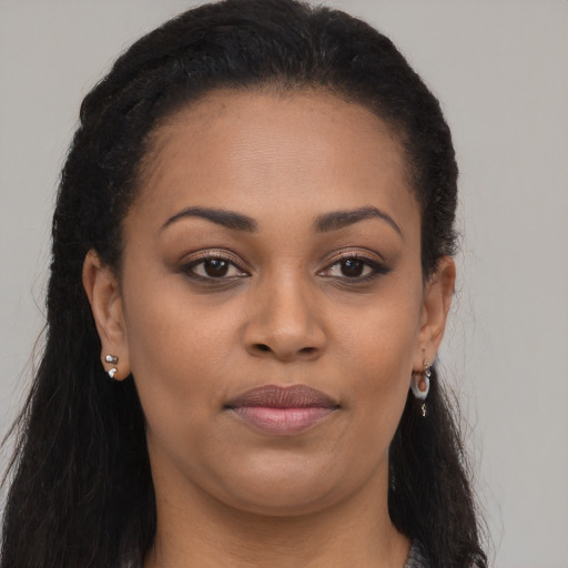 Joyful black young-adult female with long  brown hair and brown eyes