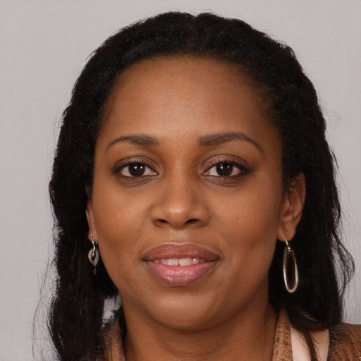 Joyful black young-adult female with long  brown hair and brown eyes