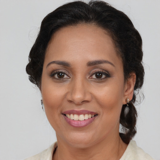 Joyful latino adult female with medium  brown hair and brown eyes