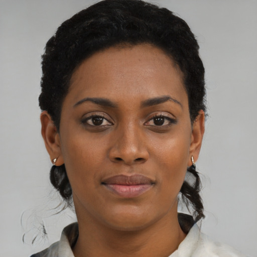 Joyful black young-adult female with medium  black hair and brown eyes