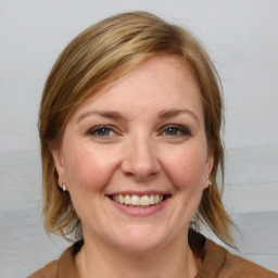 Joyful white young-adult female with medium  brown hair and blue eyes