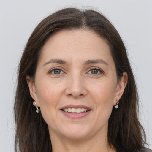 Joyful white adult female with long  brown hair and grey eyes